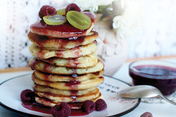 Pancakes with raspberry and jam on white background