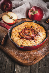 Traditional autumn baking, recipes for thanksgiving, Homemade wholegrain apple galette pie with organic apples and cinnamon, In iron cast pan, old wooden table, copy space