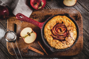 Traditional autumn baking, recipes for thanksgiving, Homemade wholegrain apple galette pie with organic apples and cinnamon, In iron cast pan, old wooden table, copy space top view