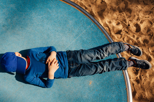 Boy taking a pretend nap on a playground