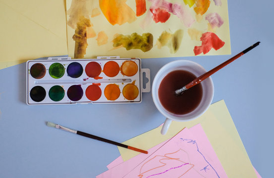 Watercolours and Child's Artwork on the Table