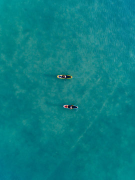 Aerial view of women paddleboarding in the ocean