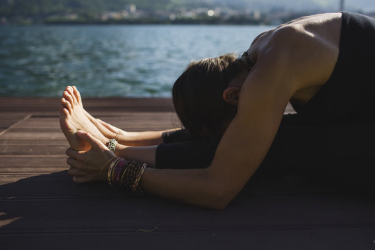 Woman doing yoga pose: Paschimottanasana