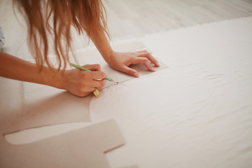 girl making a pattern sketch with a pencil and a template
