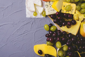 Cheese plate served with fresh grapes and pears