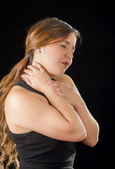 Fototapeta premium Beautiful young lady Suffer crick after workout in a black background
