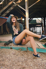Funny laughing young woman with long legs dressed in gumshoes, casual style