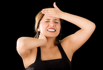 Obraz premium Close up of a beautiful young lady Suffer crick after workout with a hand in her forehead, in a black background