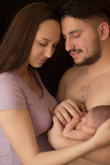 newborn baby mom daddy hands on family