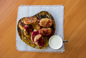 hot pie with berries, fried in oil, lined in a dish, a mug of cold milk, on a napkin