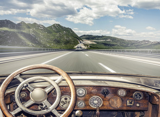 Retro car on the highway road. View from the cockpit.