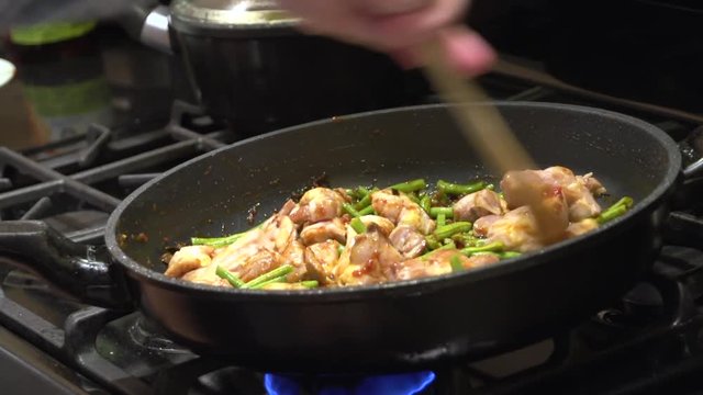 Cooking Thai food, Gai Pad Prick Gaeng, in a hot frying pan.