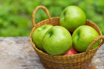 red and green apples with flowers on wooden