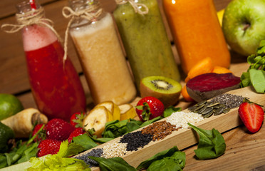 Assortment of fruit and vegetable smoothies in glass bottles with straws