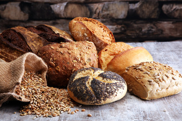 Different kinds of bread and bread rolls on board. Kitchen or bakery poster design.