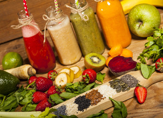 Obraz na płótnie Canvas Assortment of fruit and vegetable smoothies in glass bottles with straws