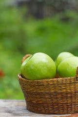red and green apples with flowers on wooden