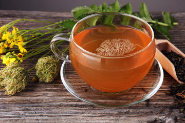 A cup of tea with tea leaves. Tea among the herbs.