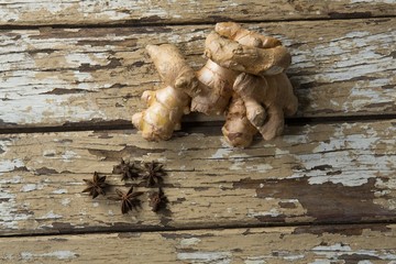 Overhead view of fresh gingers and star anise on weathered table