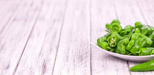 Wooden table with Raw Pimientos, selective focus