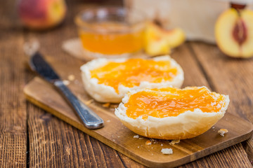 Peach Jam on wooden background; selective focus