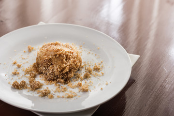 Plum dumplings on the white round plate with brown wooden table in the background