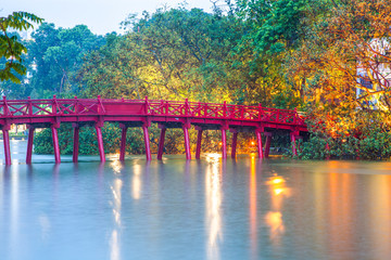 hanoi Red Bridge at night. The wooden red-painted bridge over the Hoan Kiem Lake connects the shore and the Jade Island on which Ngoc Son Temple stands.