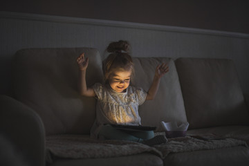 Little girl with tablet in a dark room
