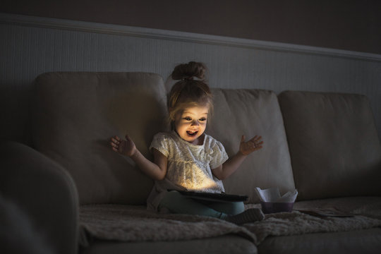 Little girl with tablet in a dark room