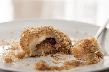 Closeup macro of plum dumplings on the plate with metal fork