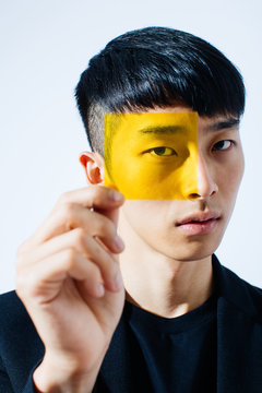 Portrait man looking through yellow glass