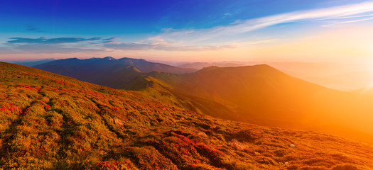 Fototapeta na wymiar Amazing mountain landscape with colorful vivid sunrise on theblue sky, natural outdoor travel background. Beauty world. Panoramic view.