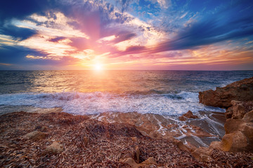 Beautiful colorful sunset at the sea with dramatic clouds and sun shining. Beauty world natural outdoors travel background