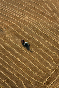 Aerial view of a tractor working in a wheat field in summer