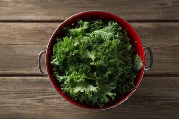Overhead view of kale in colander on table - obrazy, fototapety, plakaty