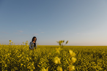 Female farmer standing in field of canola
