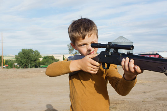 boy aims bb gun at target