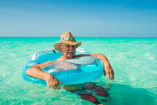 Old Man Tourist at Sunny Turquoise White Sand All Inclusive Resort Beach In Caribbean - Powered by Adobe