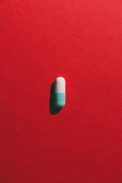 Bicolor capsule on red background from above.