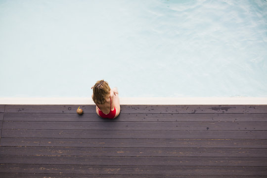 Young Attractive Woman Sitting By The Pool