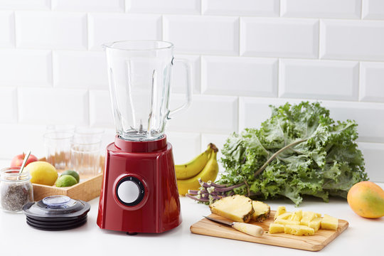 Cut pineapple on board with empty blender