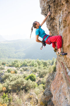 Young woman rock climbing in summer