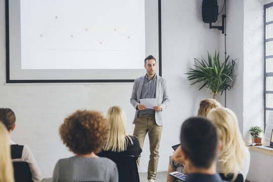 Businessman giving presentation to colleague in office meeting