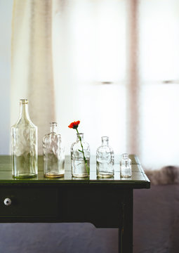 Glass bottles of decreasing size on table