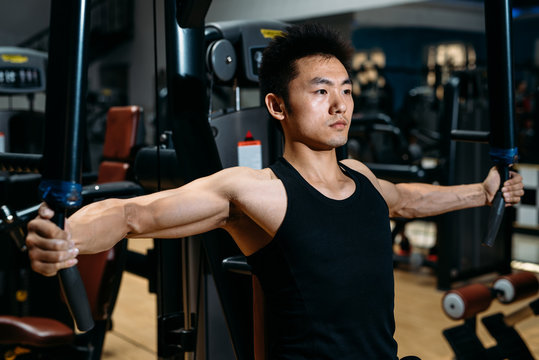 Man doing chest exercises with a fitness machine