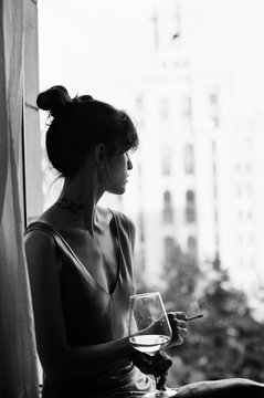Silhouette of a woman having wine and cigarette