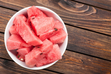 watermelon slices in plate on dark wooden background top view