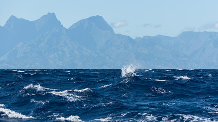 View of Tahiti from the sea in a windy day, foam and waves
