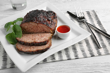Plate with tasty baked turkey meatloaf on table