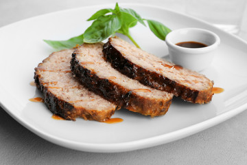 Plate with sliced tasty turkey meatloaf on table